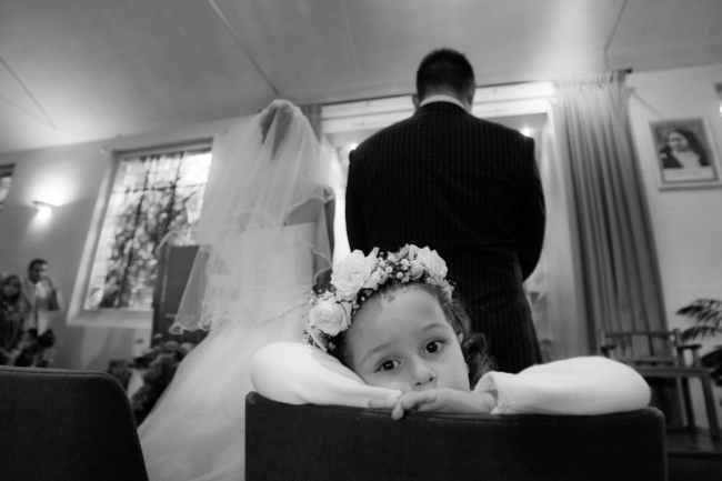 © Nicolas Gornas Photographie de mariage petite fille fixant l'objectif à l'église